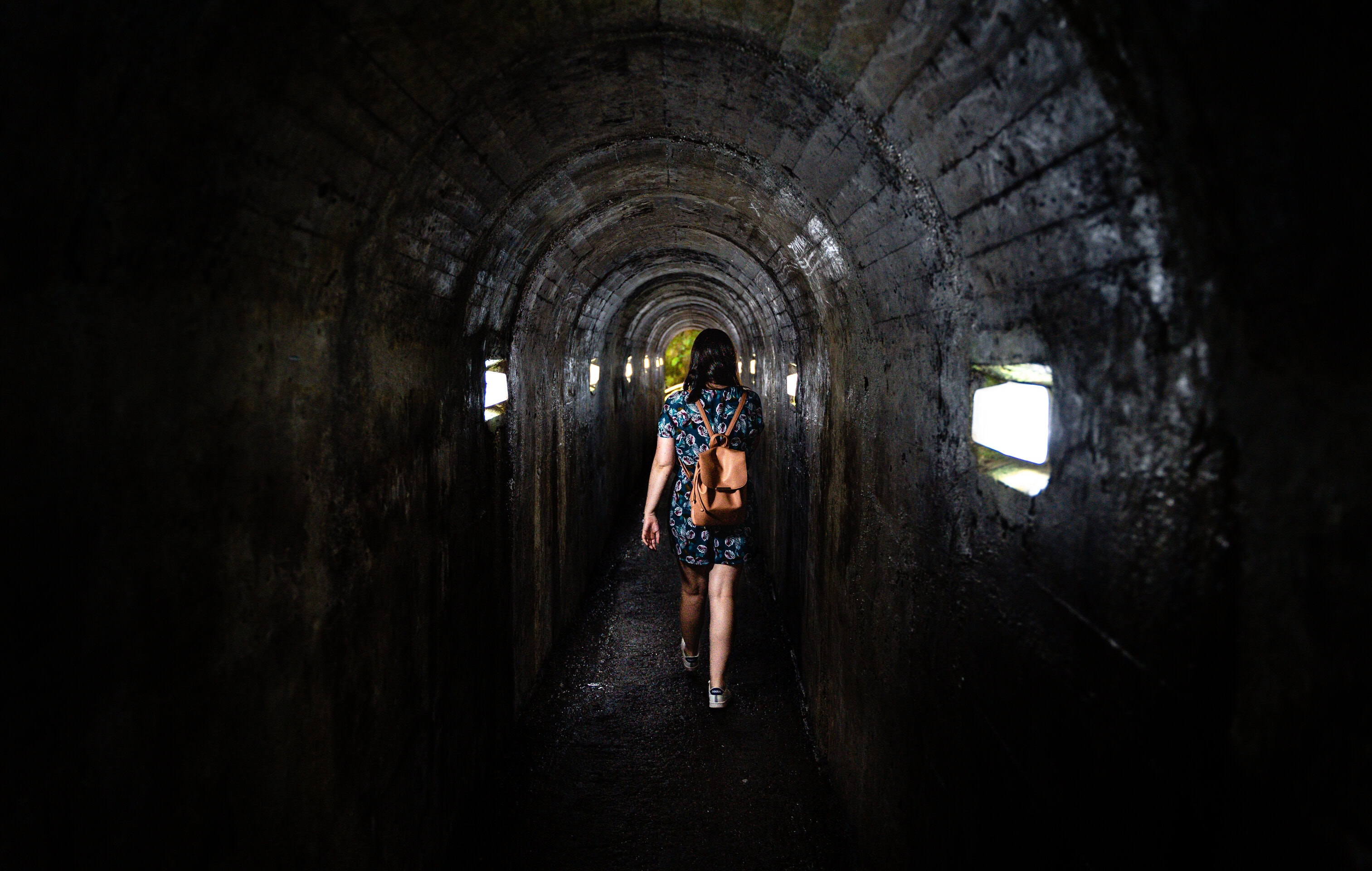 Visitor entering Gruta do Natal lava tube on Terceira Island