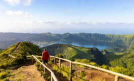 a man doing a hiking trail with a beautiful landscape of the green island of the Azores - São Miguel in Portugal